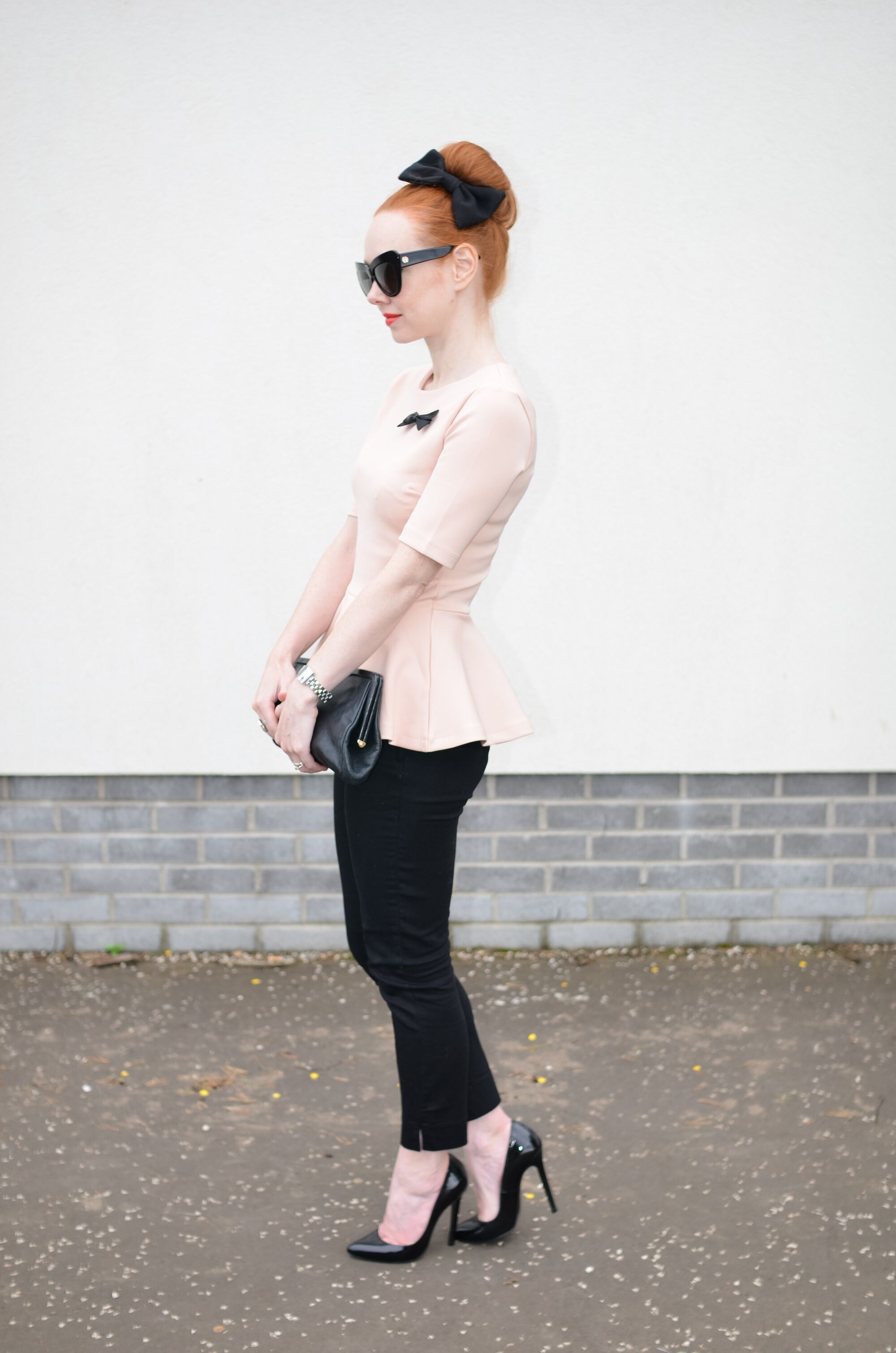 pink peplum top with black ankle pants and high heels