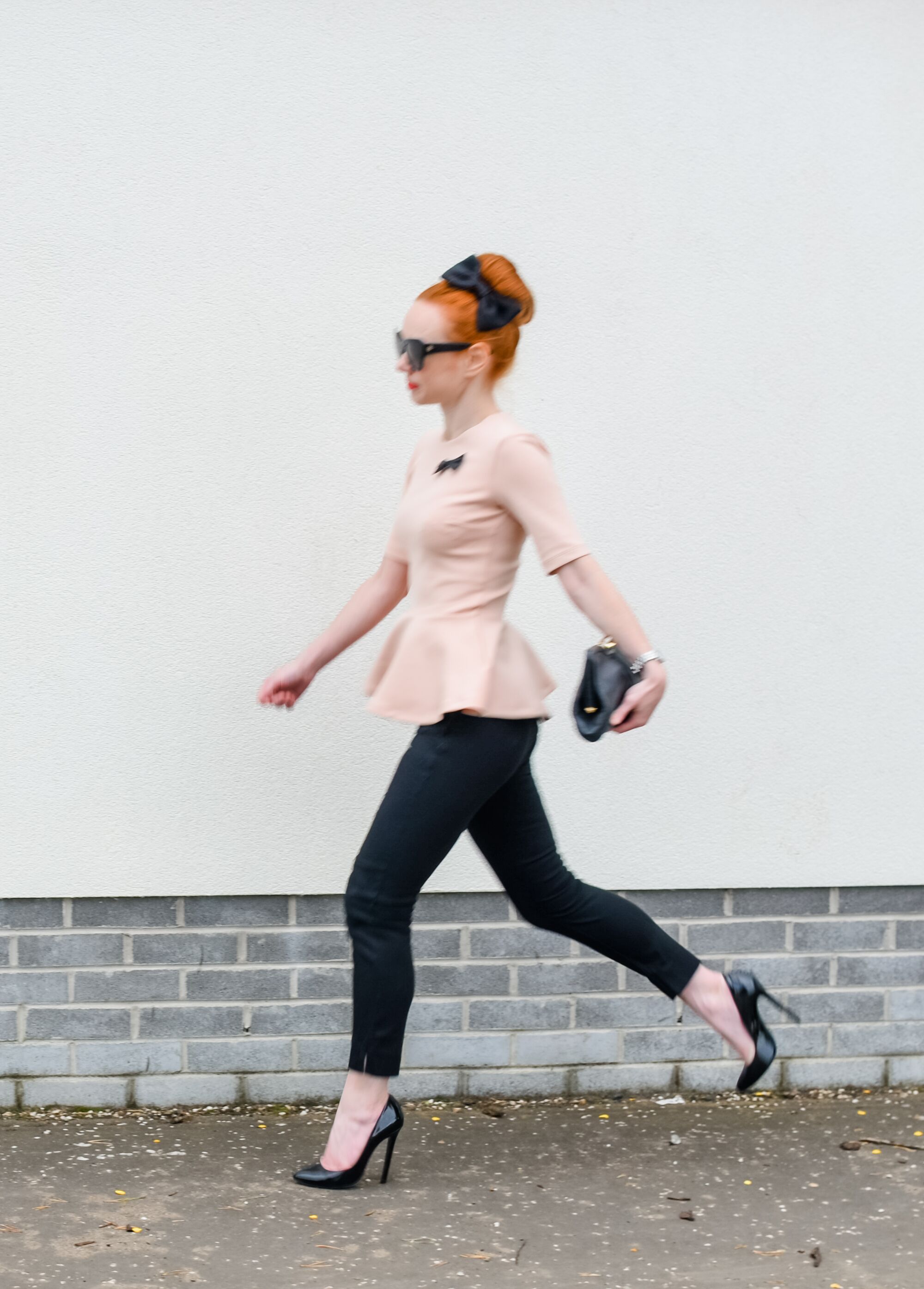 pink peplum top with black ankle pants and high heels