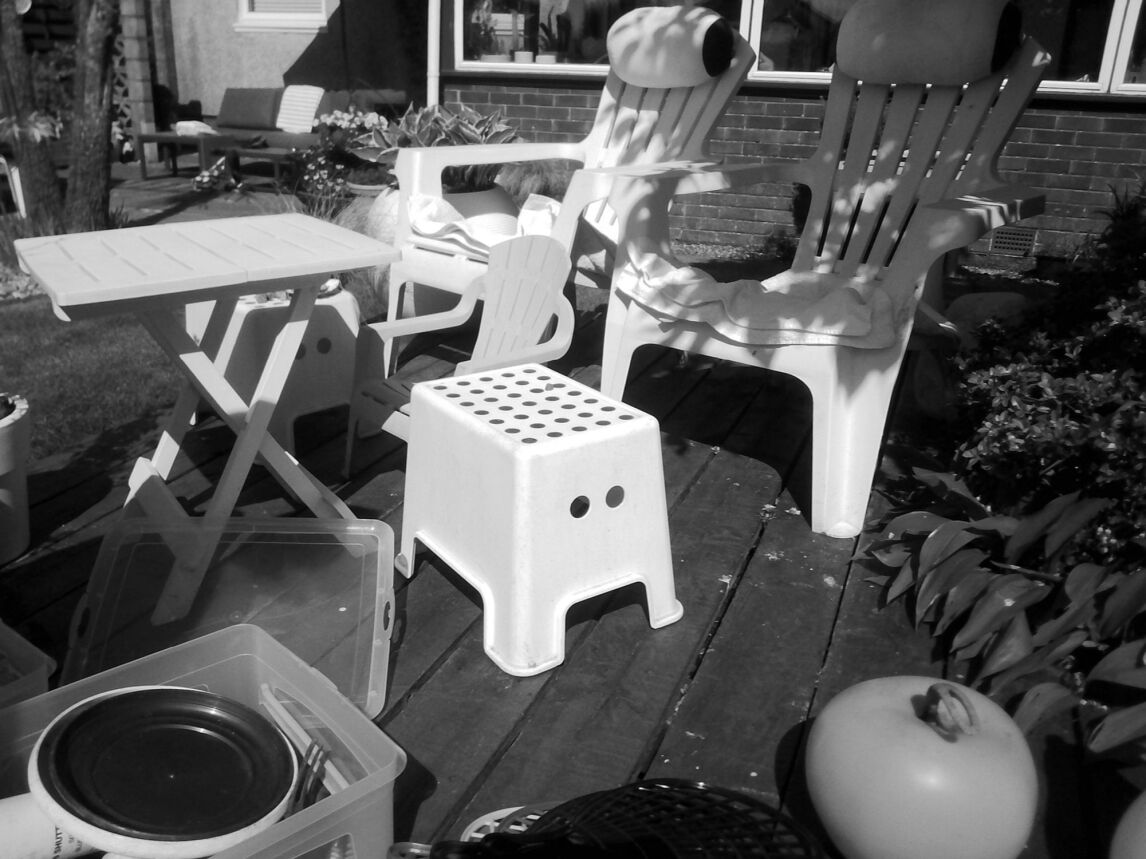 a black and white photo of two deckchairs in the sun